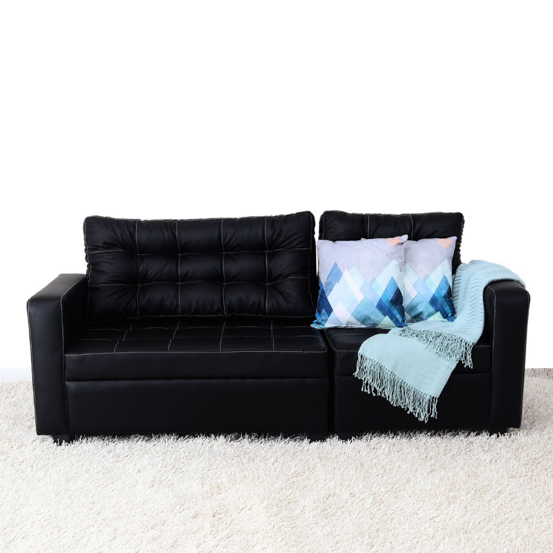 Black modular sofa with tufted cushions, armrests, and blue accent pillows