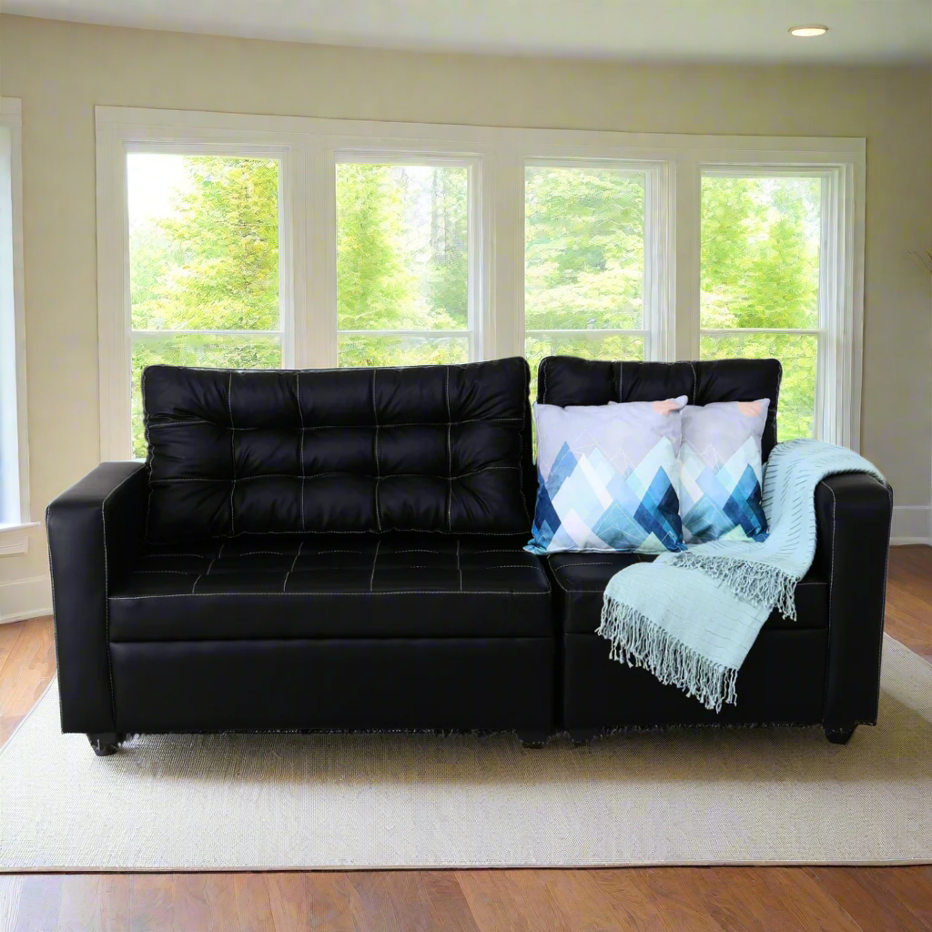Black modular sofa with tufted cushions, armrests, and patterned blue pillow