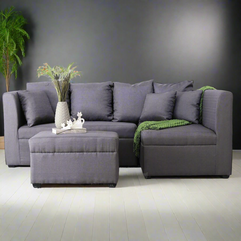 Gray L-shaped sofa with chaise, tufted cushions, and square throw pillows.