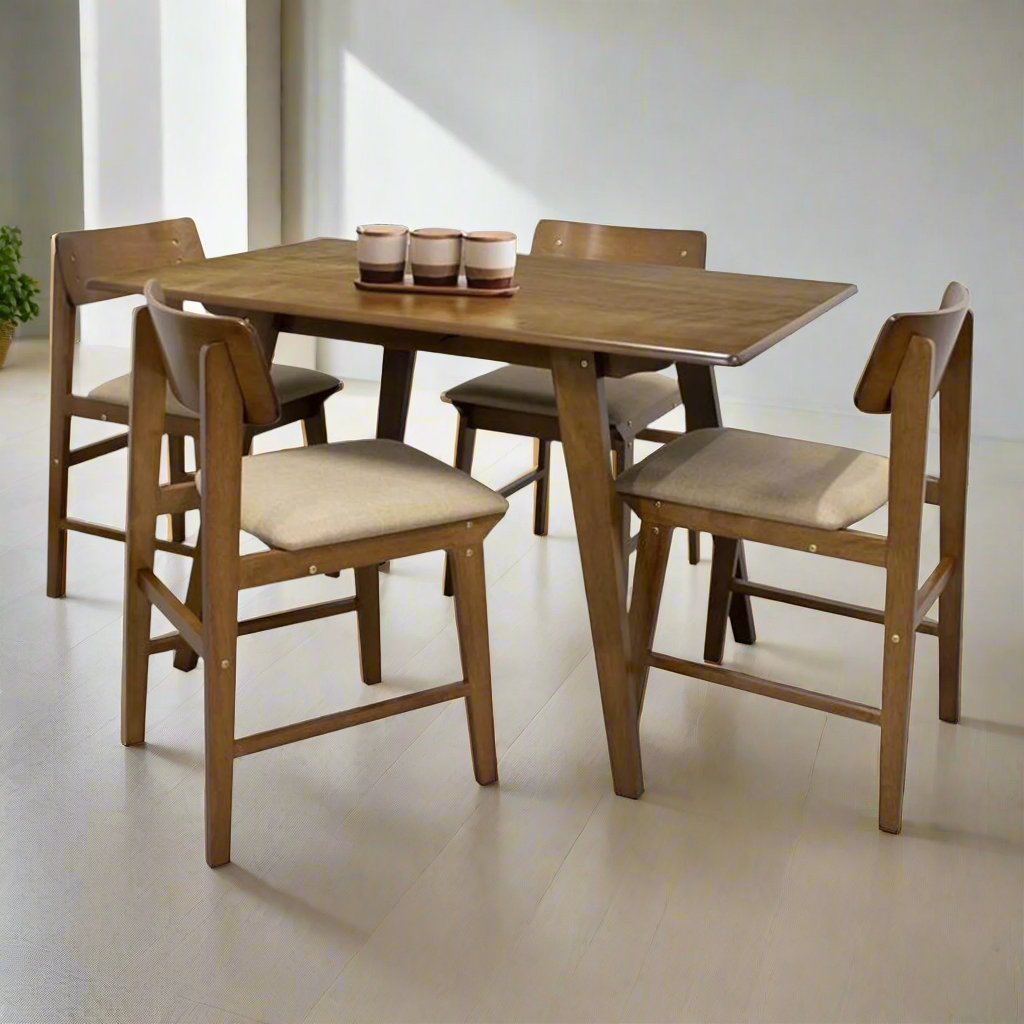 Dining table set for four with four wooden chairs and beige cushions; cups on table