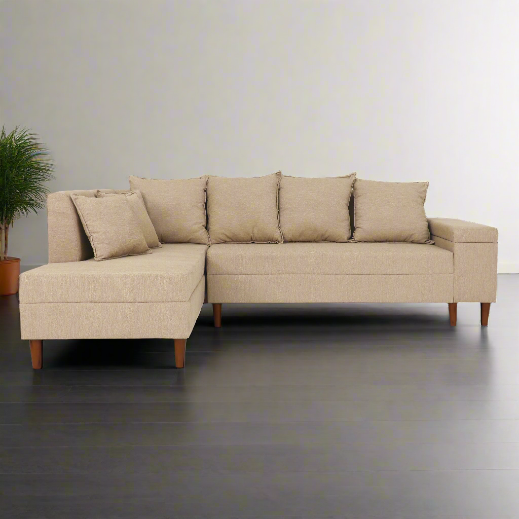 Beige L-shaped sectional with left chaise, boxy arms, four pillows, and wooden feet