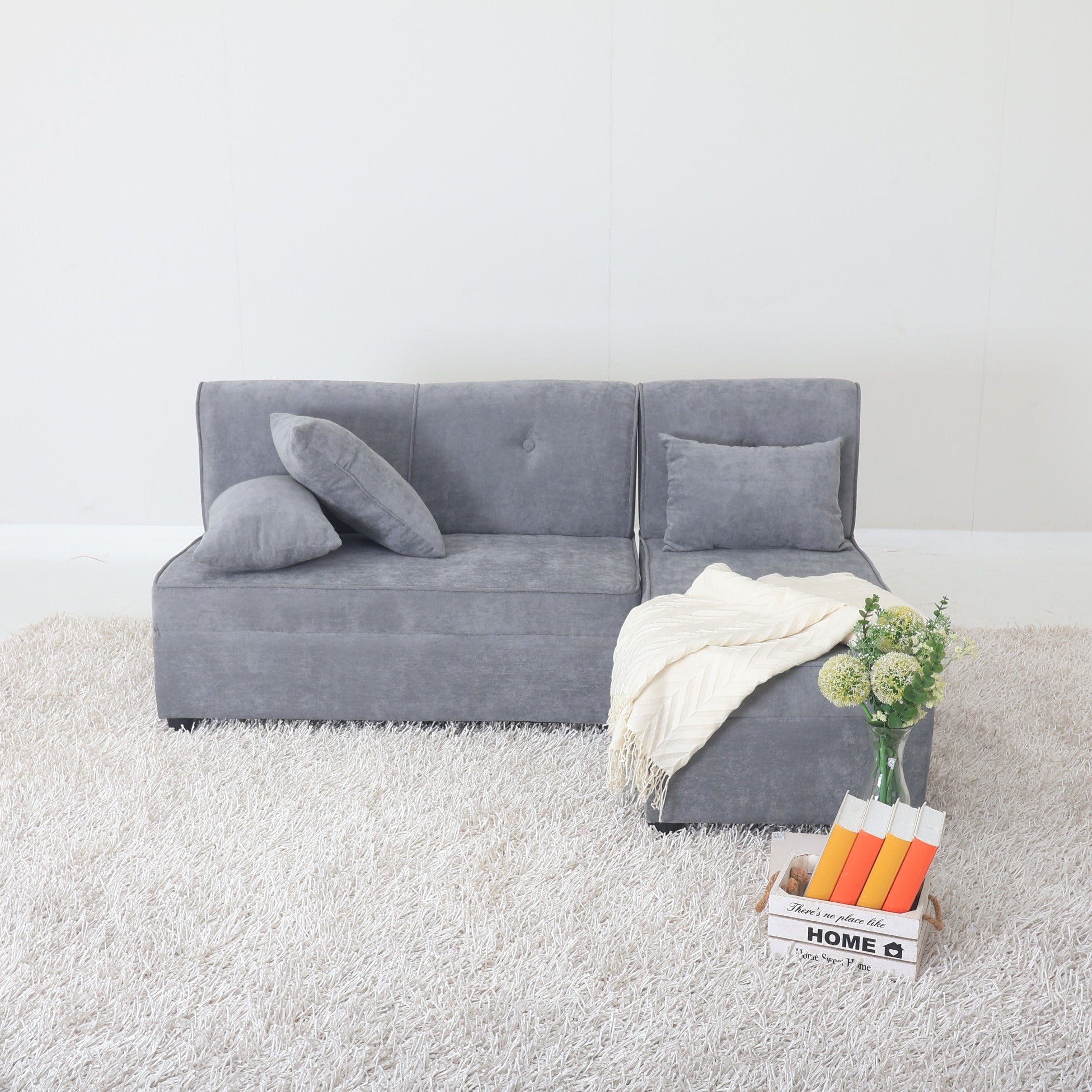 Grey L-shape sofa with tufted back cushions and wide chaise section