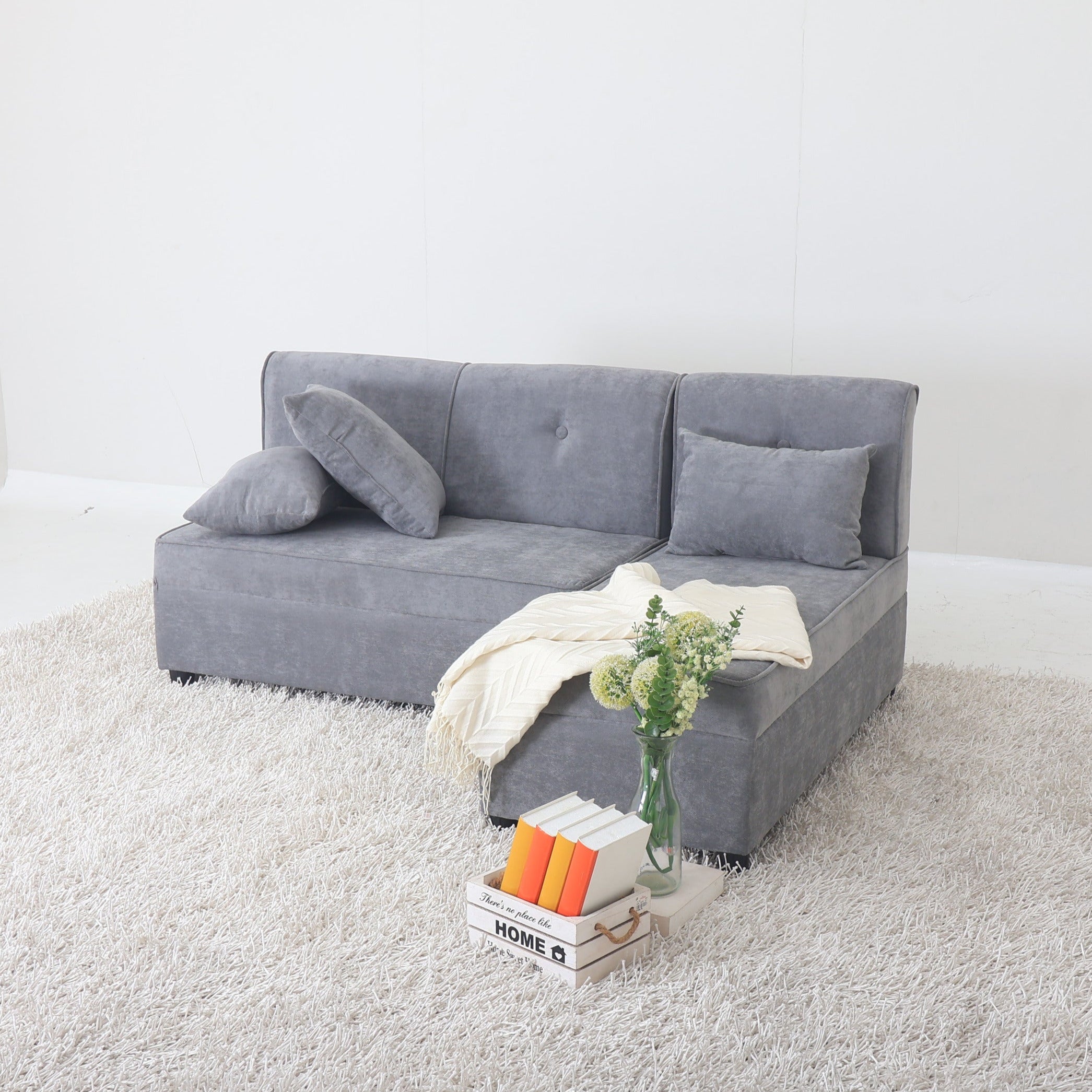 Grey L-shape sofa with chaise and back cushions, styled with throw blanket