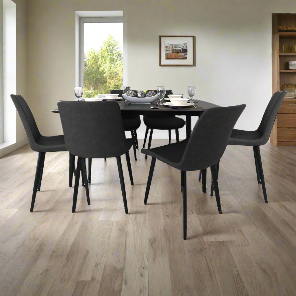 Rectangular dining table with six dark gray upholstered chairs and slim black legs