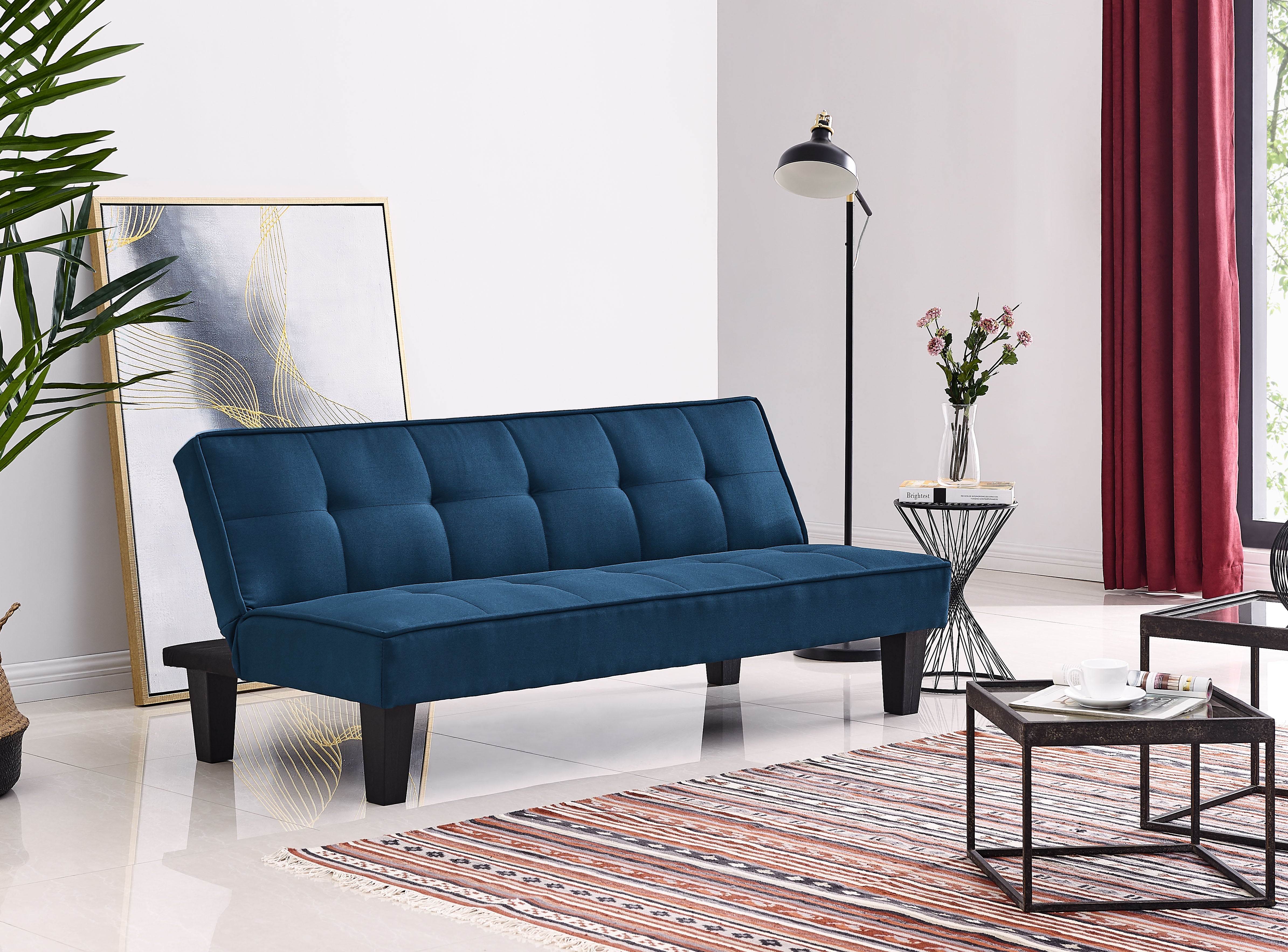Blue sofa bed with tufted backrest and padded seat, tapered dark legs