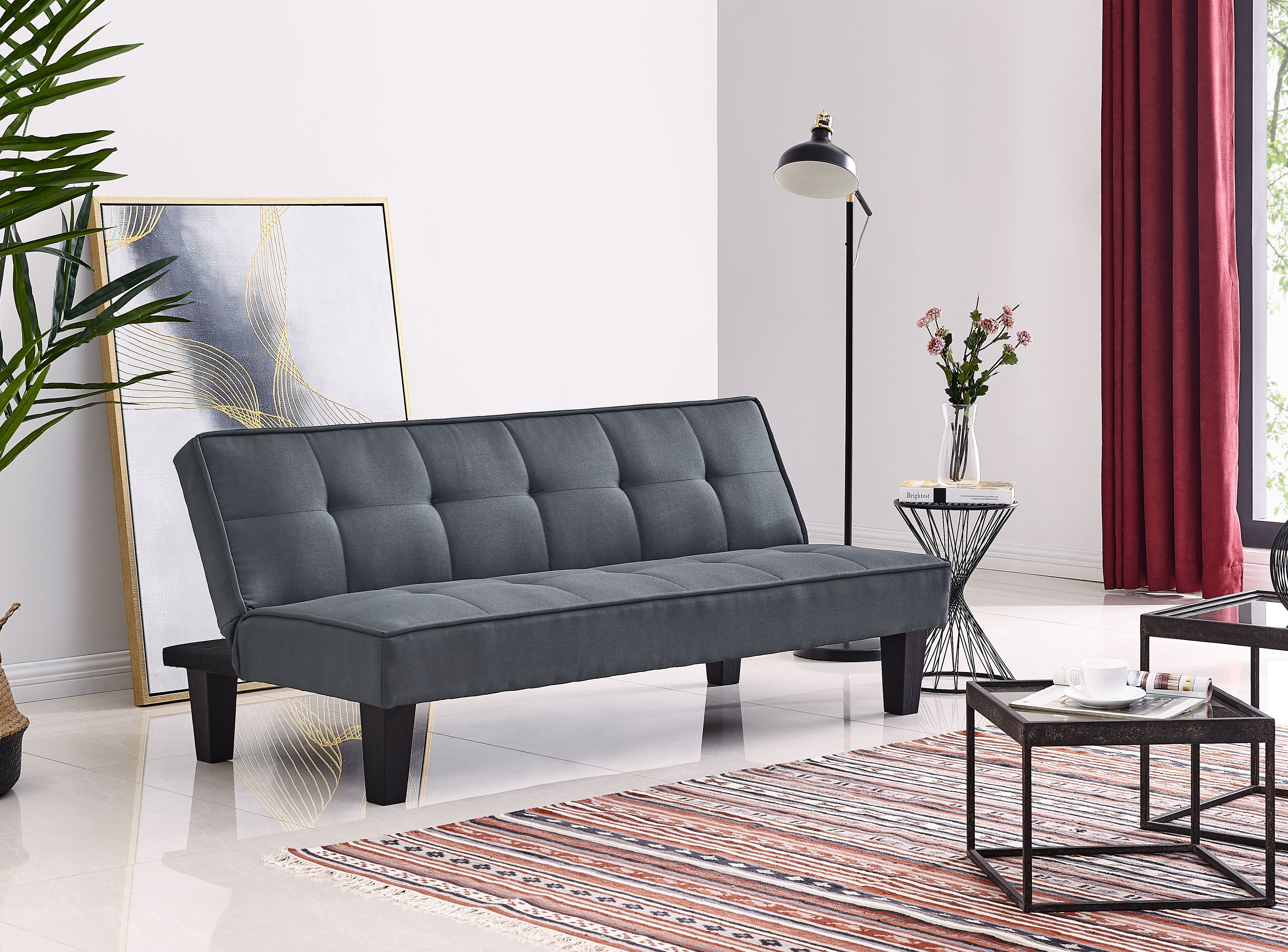 Charcoal sofabed with tufted seat and backrest, rounded armrests, tapered feet
