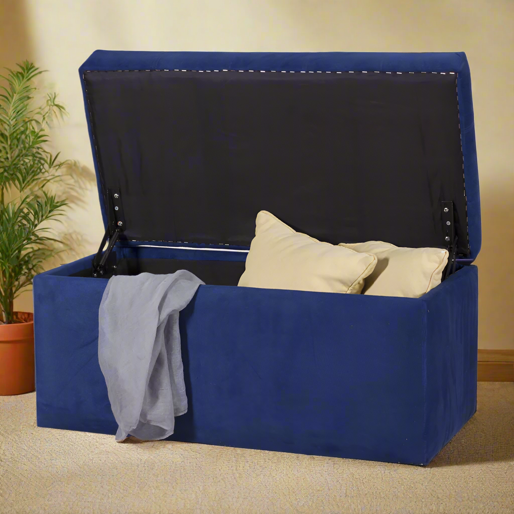 Reid ottoman in blue fabric with open lid and two cream pillows inside.
