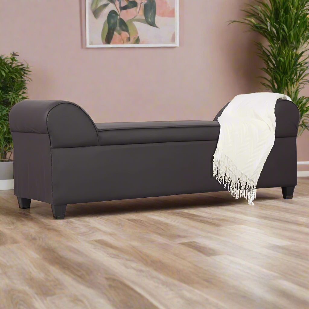 Lounge sofa with rounded arms, dark upholstery, and white throw blanket draped over seat