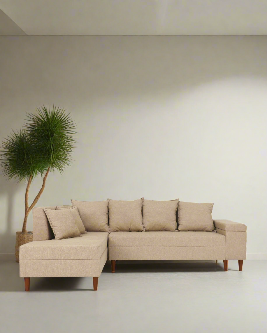 Beige L-shaped sofa front view with left chaise, tufted back cushions and four throw pillows