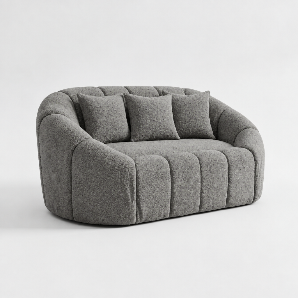 Gray 3-seater sofa with rounded arms and tufted seat cushions, three back pillows
