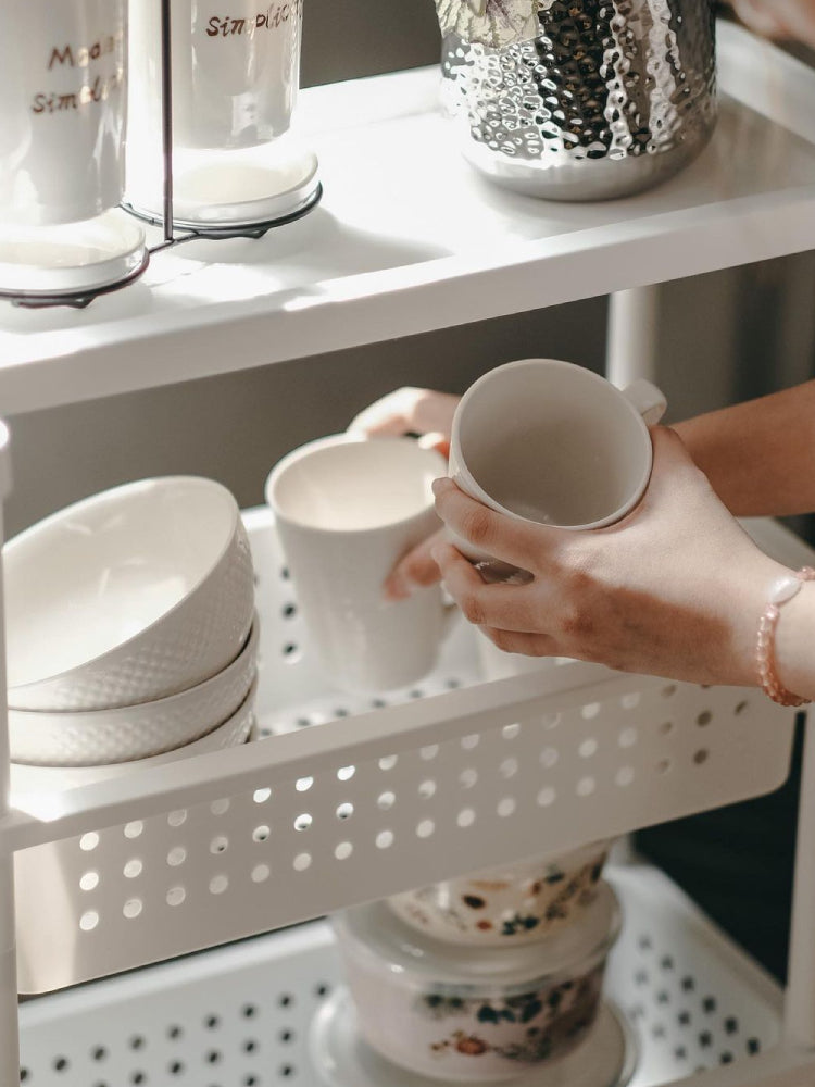 White perforated trolley shelf with a mug being set onto the cart