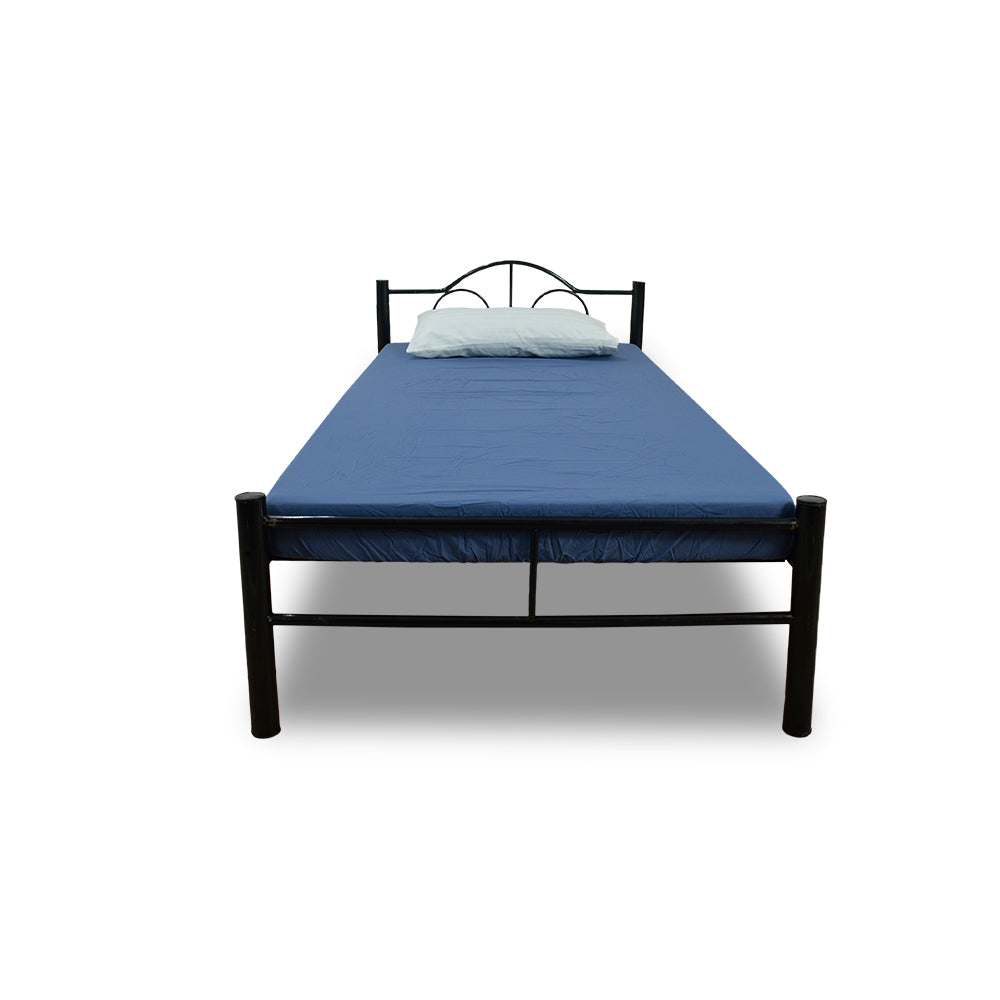 Single bed with blue top sheet and pillow, dark metal headboard and footboard.