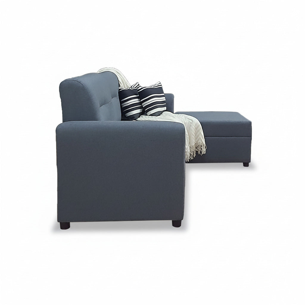 Dark gray L-shape sofa corner with striped pillow and beige throw