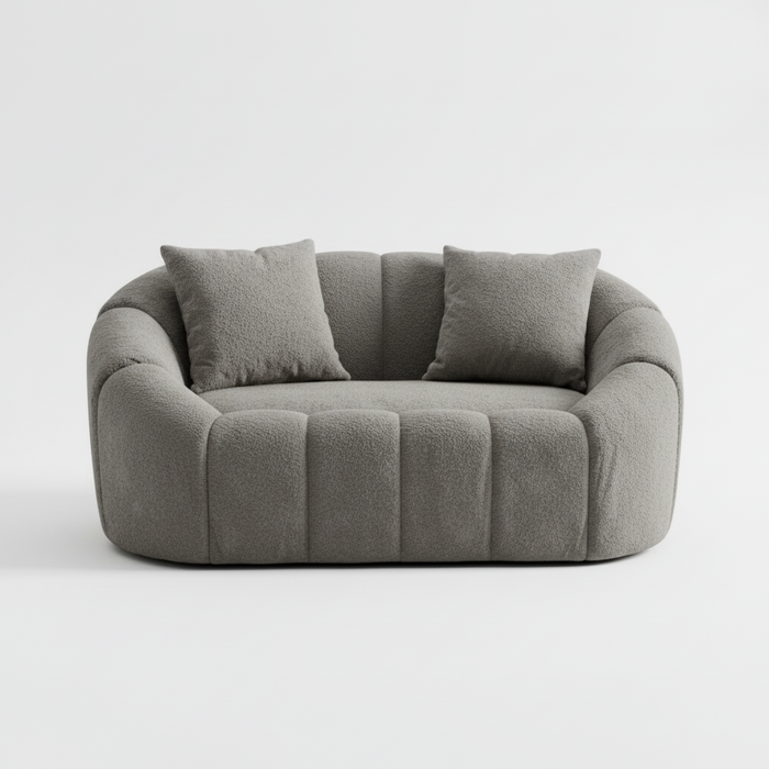 Gray 3-seater sofa, rounded arms and three back pillows over four vertical seat panels
