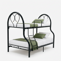 Double bunk bed with black metal frame, white mattresses, green pillows on both tiers