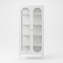 Front view of the white JIRAH display cabinet with arched glass doors and gold knobs